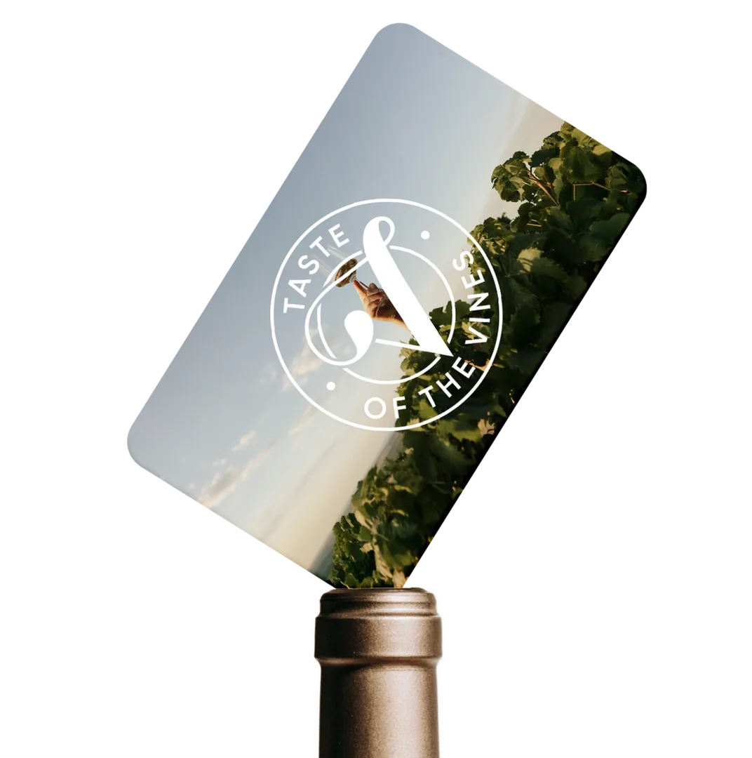 A Taste of the Vines gift card resting on the neck of a wine bottle